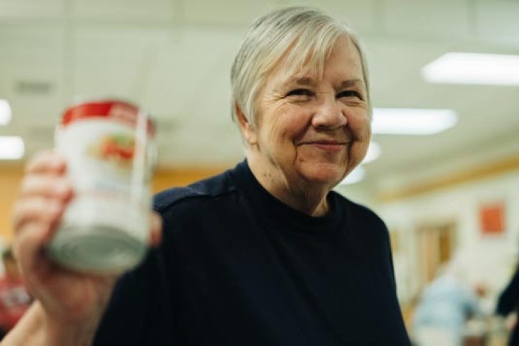 Woman holding can of food