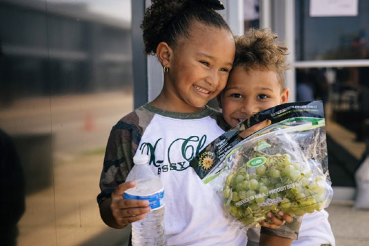 Sister with brother holding grapes