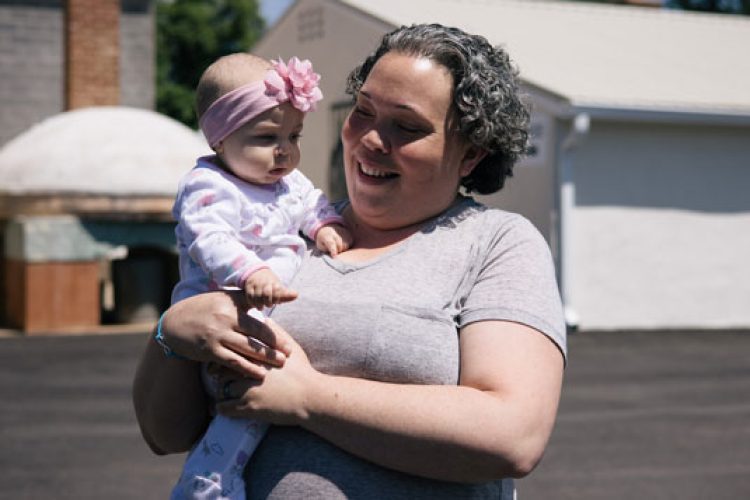 Woman holding baby outside mobile pantry