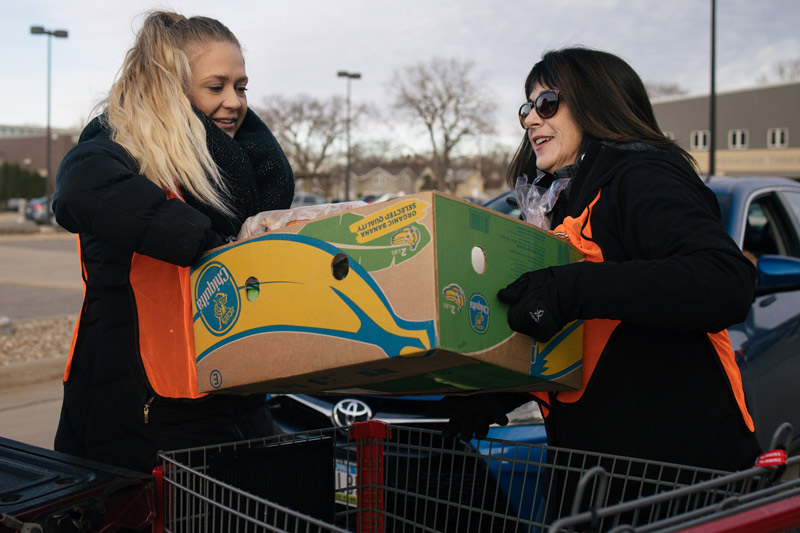 Volunteers loading food into car